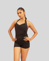 Woman wearing a black swimsuit against a gray background