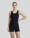 Woman wearing a black swimsuit with pink trim on a gray background
