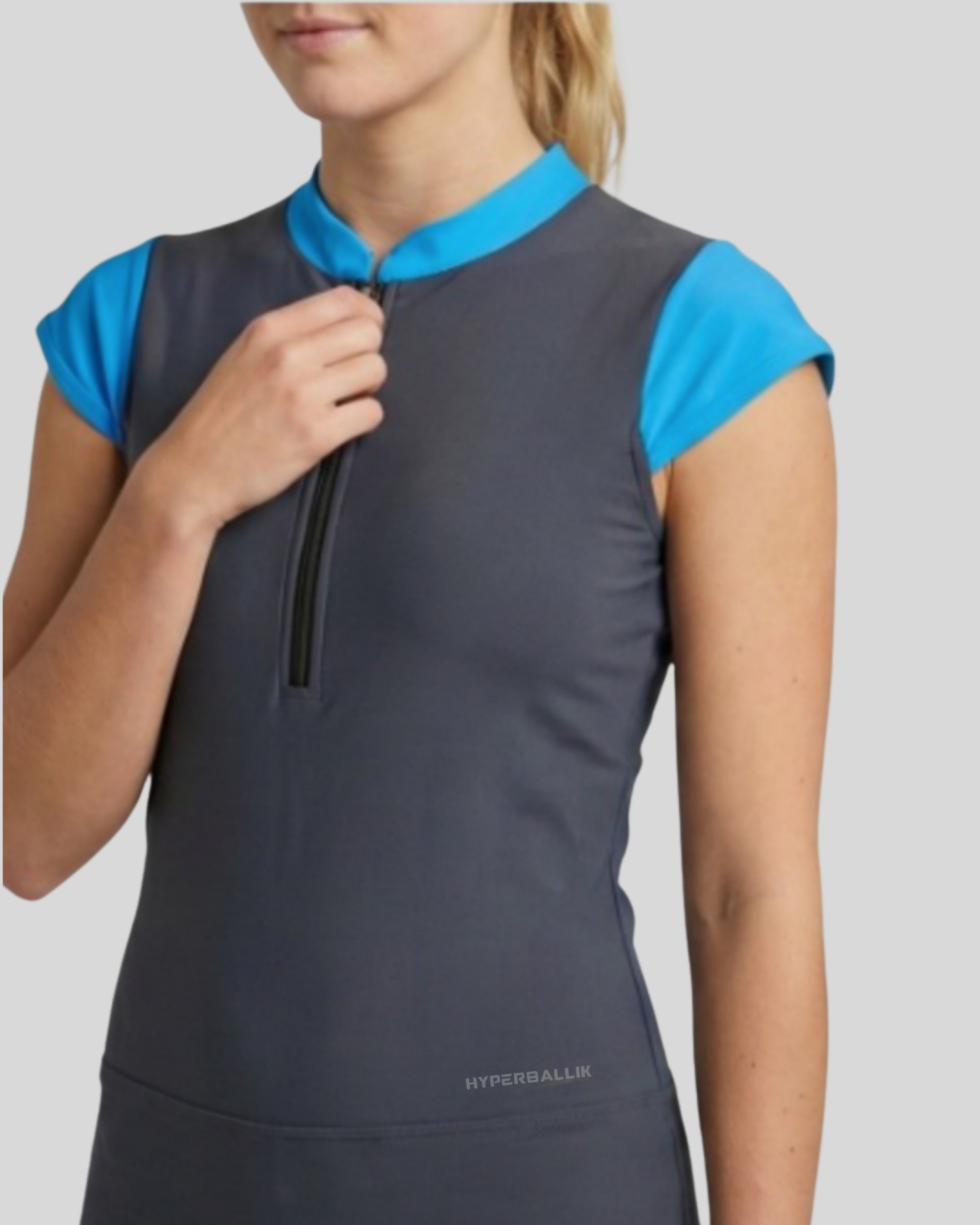 Gray sleeveless top with blue shoulders on a model against a light gray background