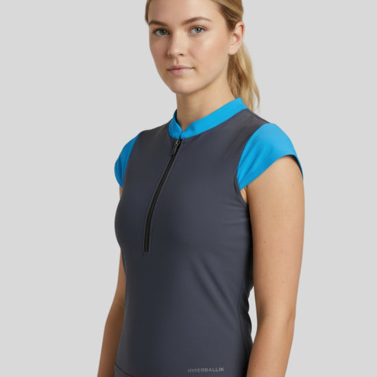 Woman wearing a gray sleeveless top with blue accents on a light gray background