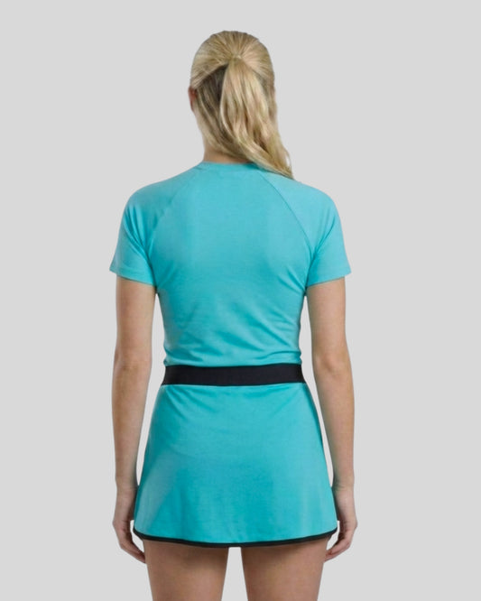 Person wearing a turquoise dress with a black belt on a light gray background