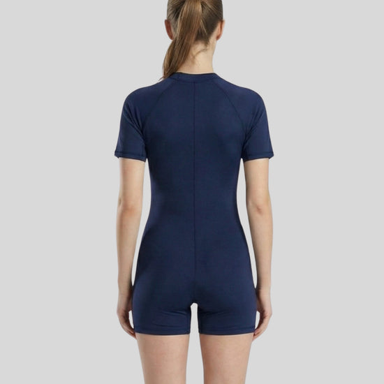 Person wearing a navy blue bodysuit on a light gray background