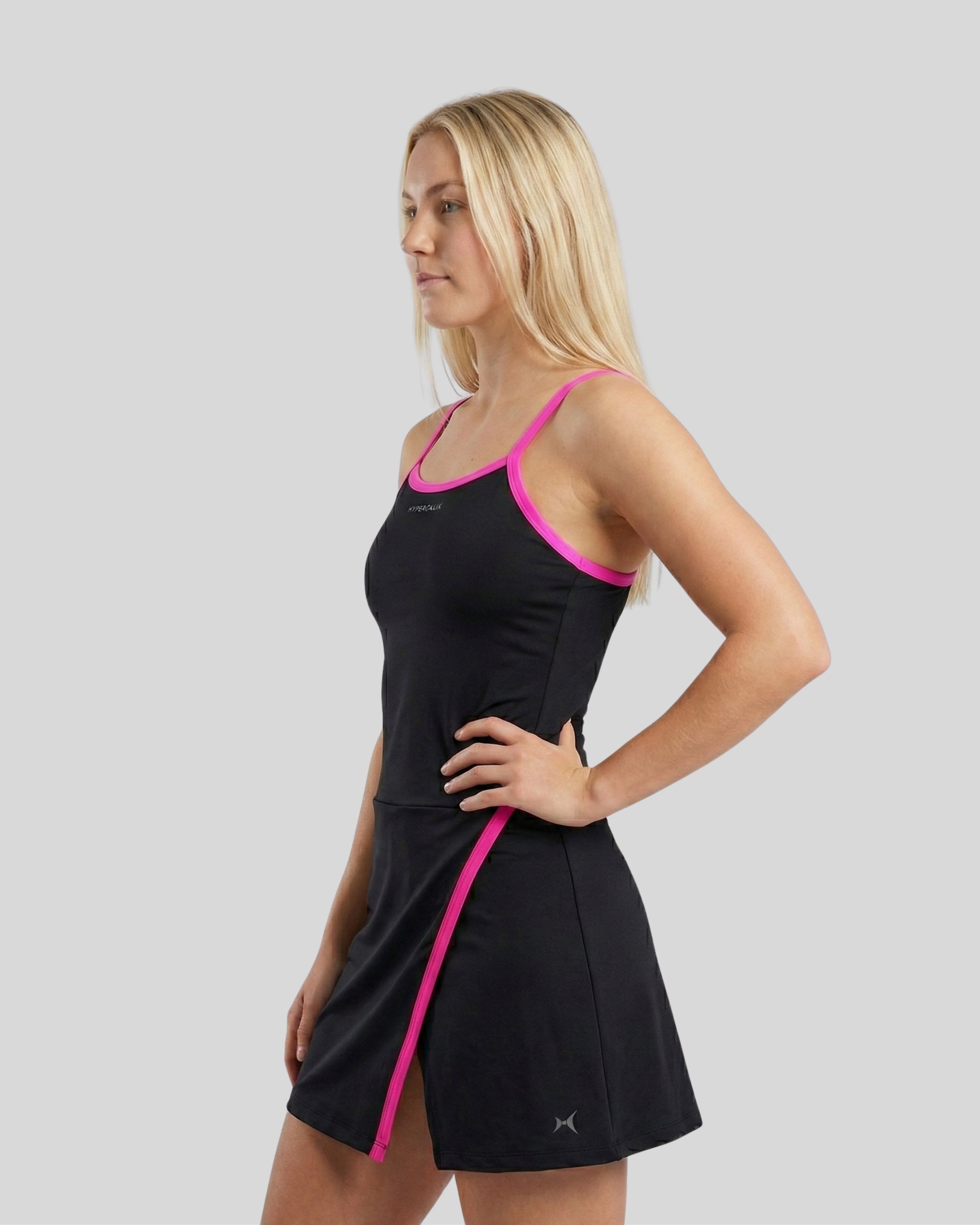 Woman wearing a black dress with pink trim on a gray background