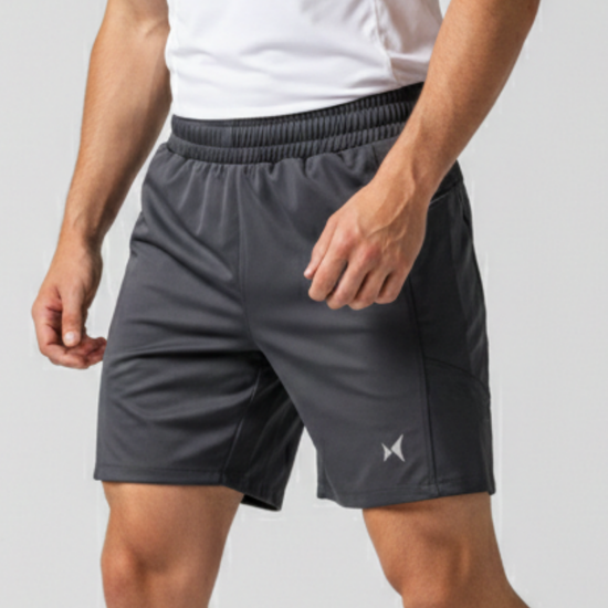 Person wearing gray athletic shorts with a brand logo on a light gray background