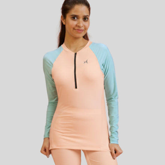 Woman wearing a peach and teal athletic outfit on a light gray background