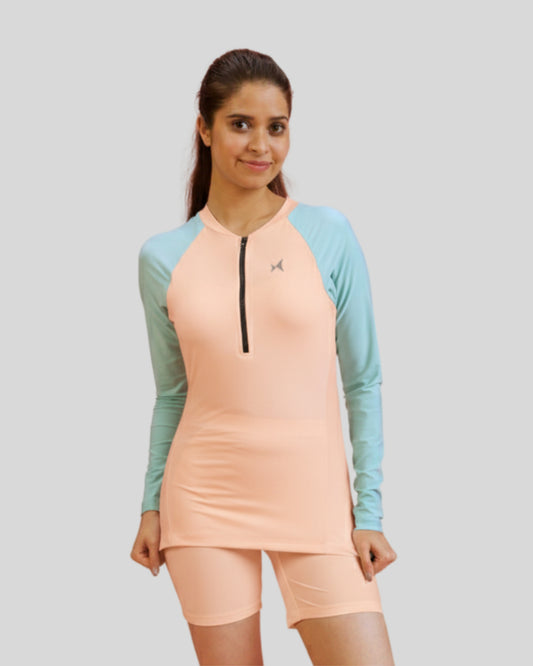 Woman wearing a peach and teal athletic outfit on a light gray background