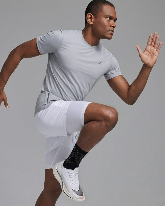 Man in athletic wear performing a squat against a gray background