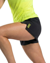 Person wearing black athletic shorts with a logo on a white background