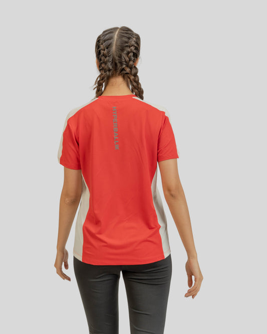 Person wearing a red athletic shirt with a logo on the back against a gray background