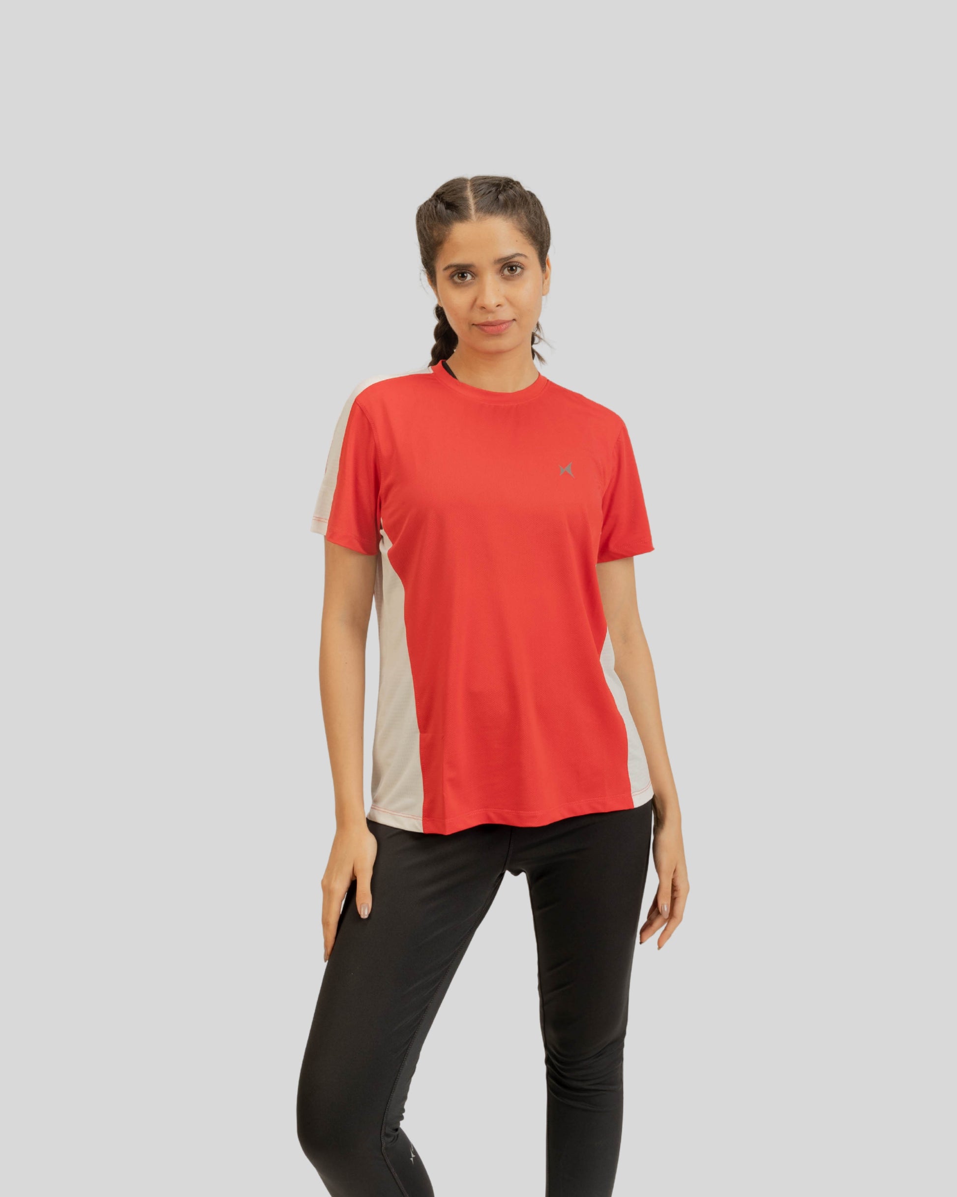 Woman wearing a red and beige athletic shirt with a logo on a gray background