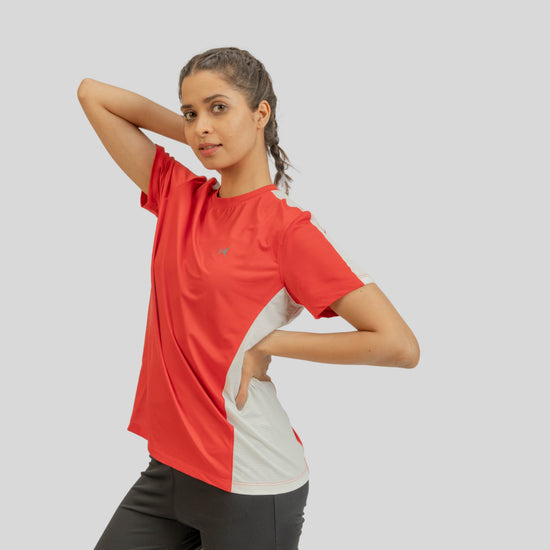 Woman wearing a red and white athletic shirt on a gray background