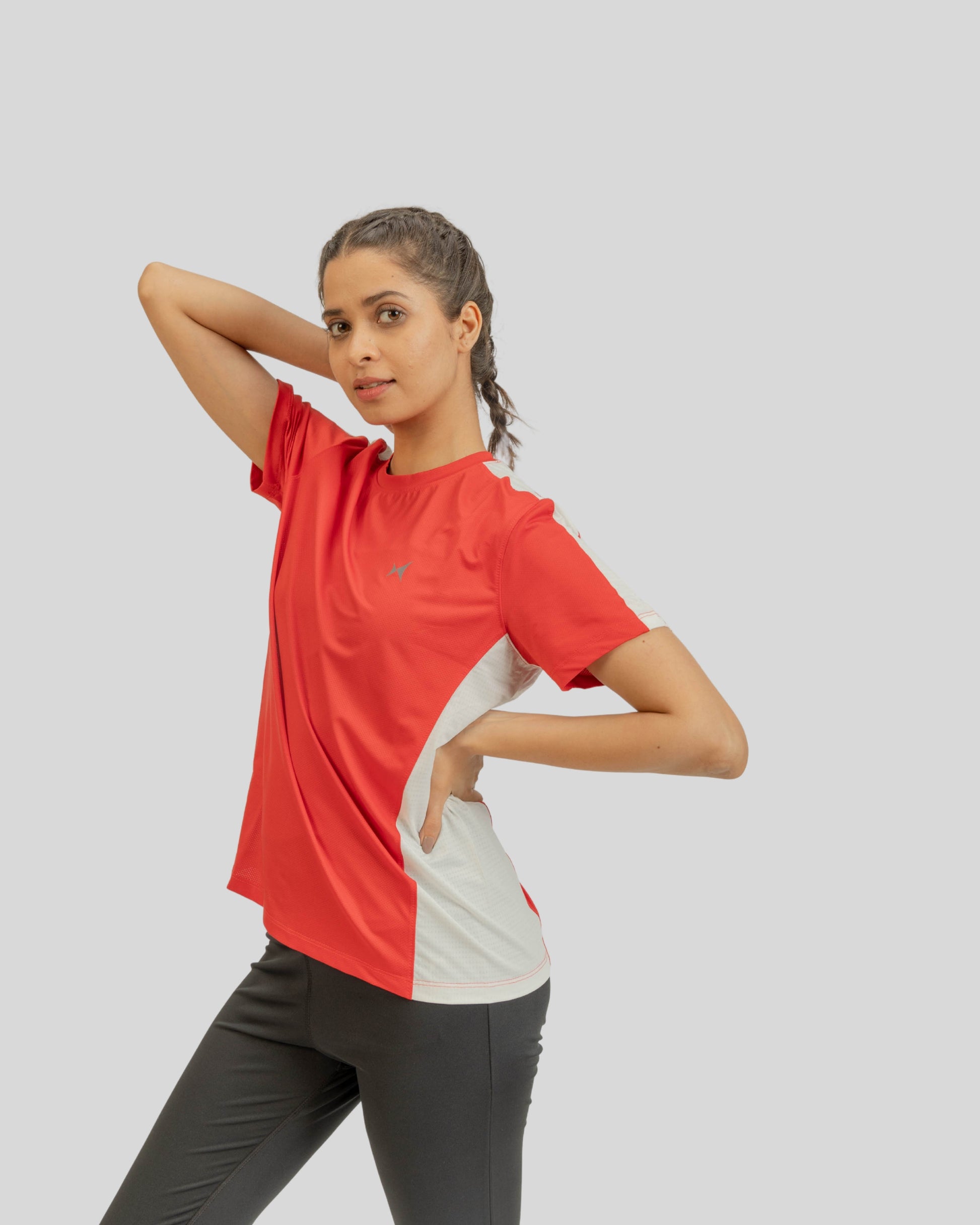 Woman wearing a red and white athletic shirt on a gray background