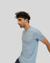 Man wearing a light blue athletic shirt on a plain background