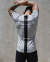 Person wearing a white athletic shirt with a black stripe on a plain background