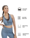 Woman wearing a blue athletic outfit with text indicating features like removable bra pads, anti-chafe stitch lines, wide no-dig band, and rapid moisture wicking.