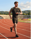 Man running on a track with a scenic background