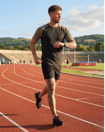 Man running on a track with a scenic background