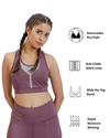 Woman wearing a purple sports bra and leggings with product features listed on the right.