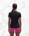 Person wearing a black t-shirt and pink shorts on a marble background
