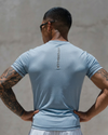 Man wearing a light blue t-shirt with 'Kanebali' branding, standing against a neutral background.