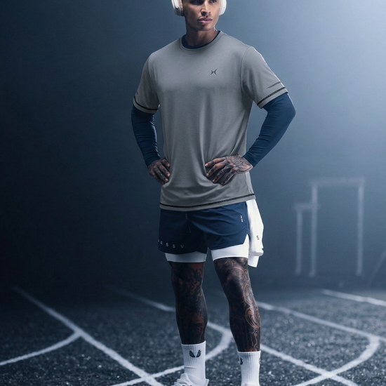 Man in athletic wear standing on a track with a dark background