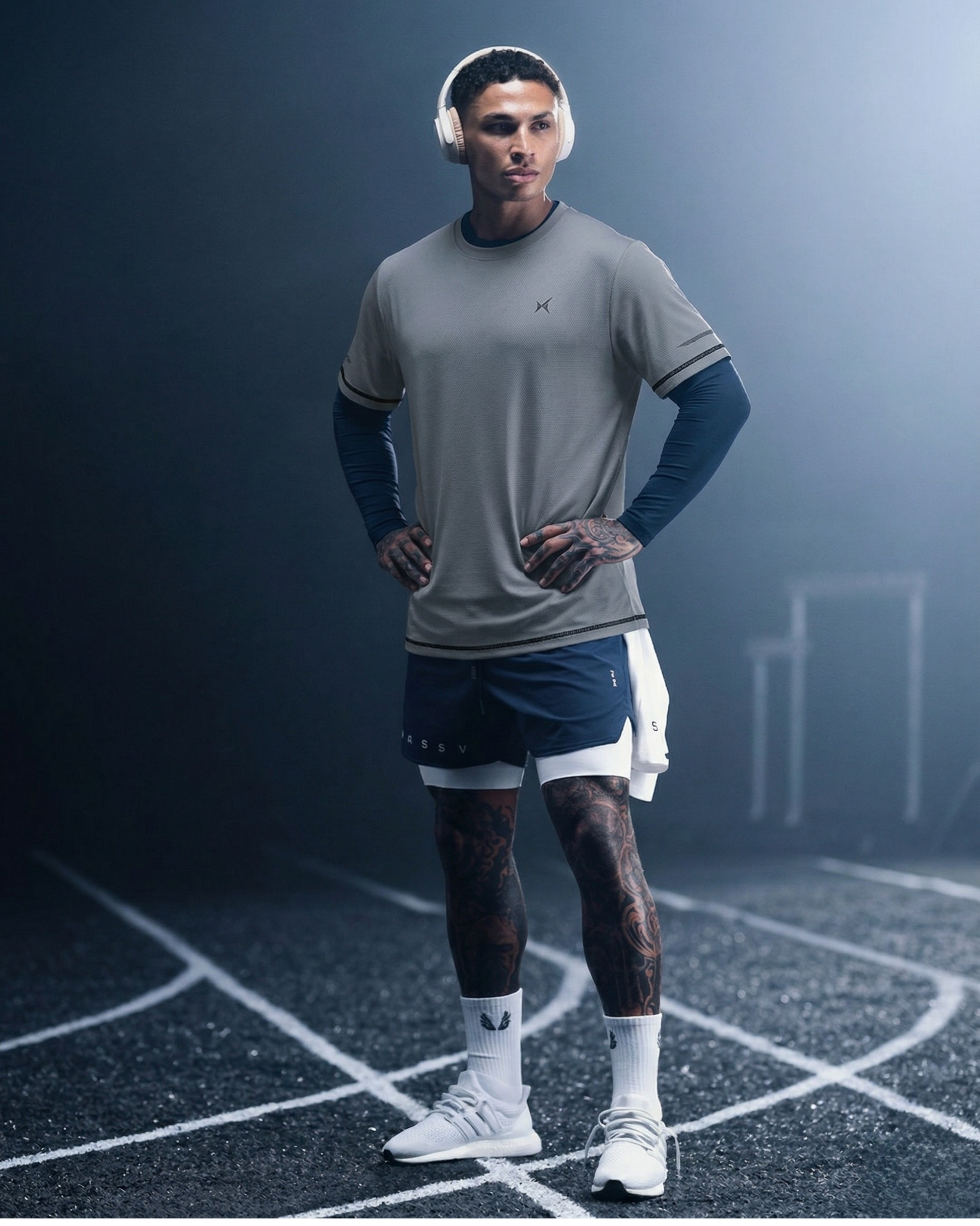Man in athletic wear standing on a track with a dark background