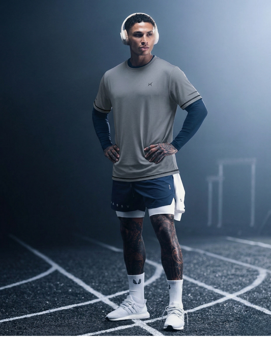 Man in athletic wear standing on a track with a dark background