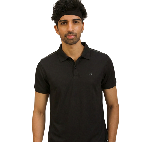 Man wearing a black polo shirt with a small logo on a white background