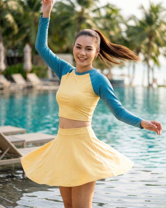 Woman wearing a yellow dress with blue sleeves on a gray background