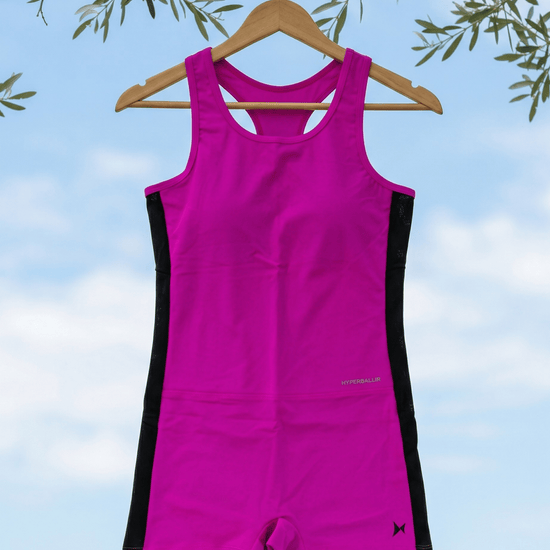 Pink and black swimsuit on a hanger against a blue sky background