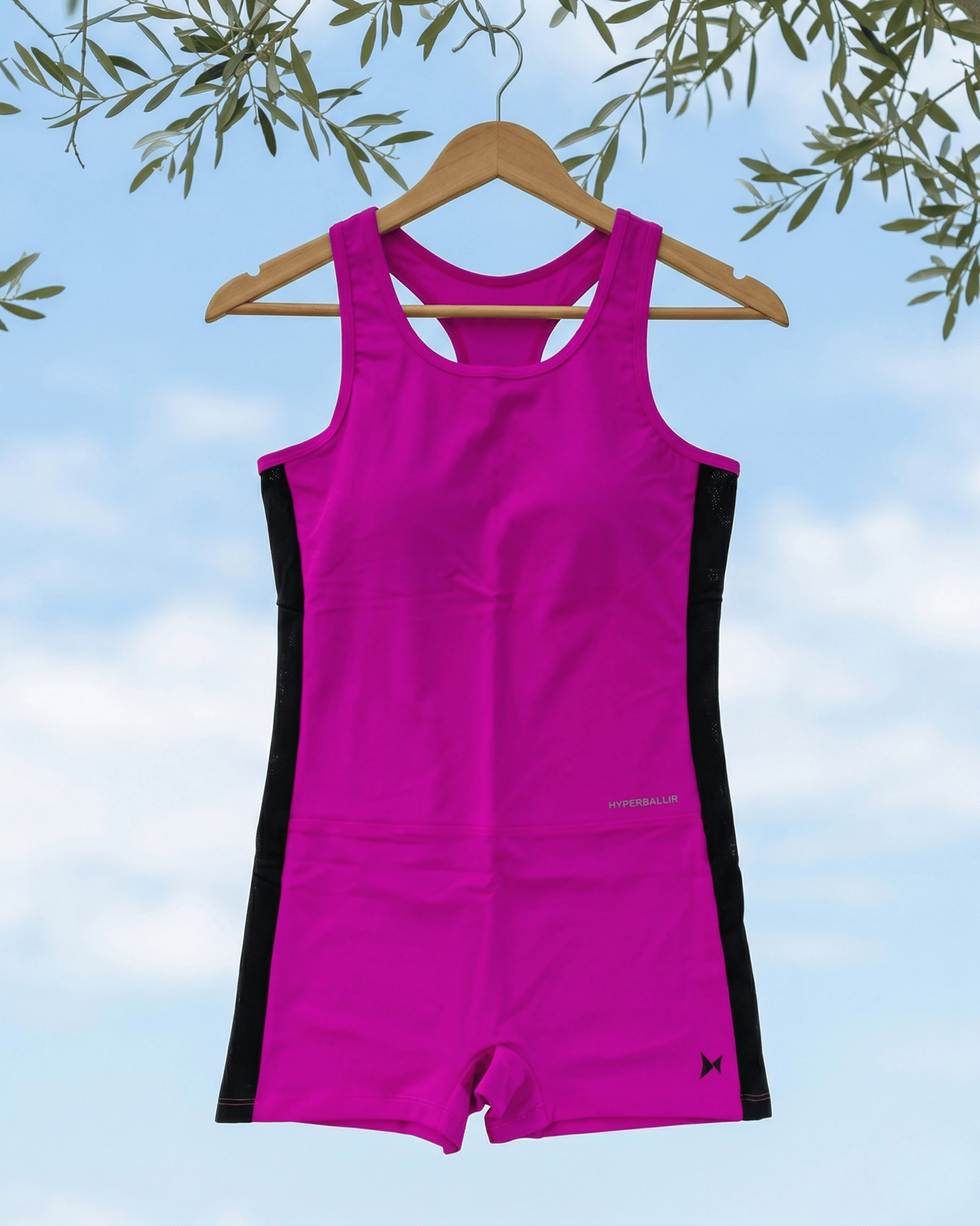 Pink and black swimsuit on a hanger against a blue sky background