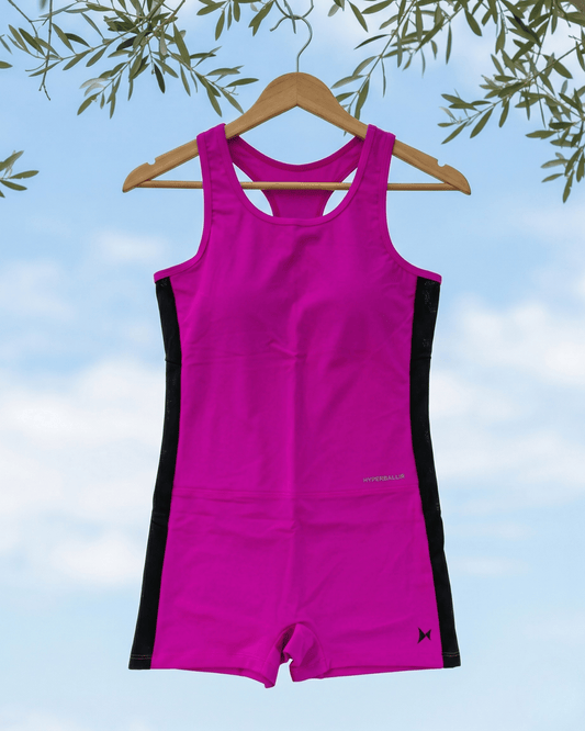 Pink and black swimsuit on a hanger against a blue sky background