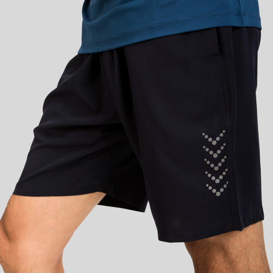 Black athletic shorts with a subtle pattern on a gray background