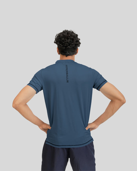 Person wearing a blue athletic shirt with a brand logo on the back against a gray background