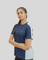 Woman wearing a blue and white athletic shirt on a plain background