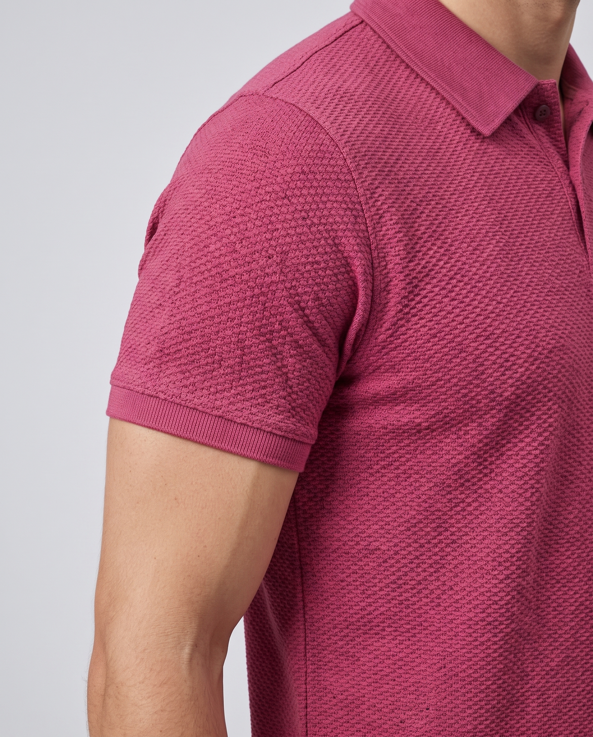 Close-up of the sleeve and bubble-knit fabric texture on a wine polo shirt