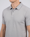 Close-up of the collar and placket on a light grey textured bubble-knit polo shirt