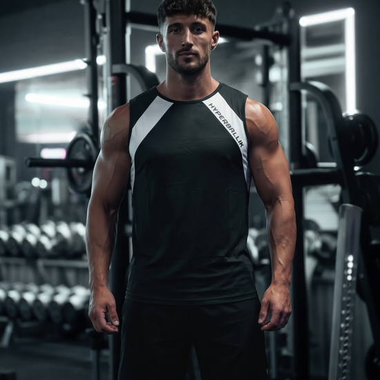 Man wearing a black Breezeflow tank top with white contrast shoulder panels, front view in a dark gym
